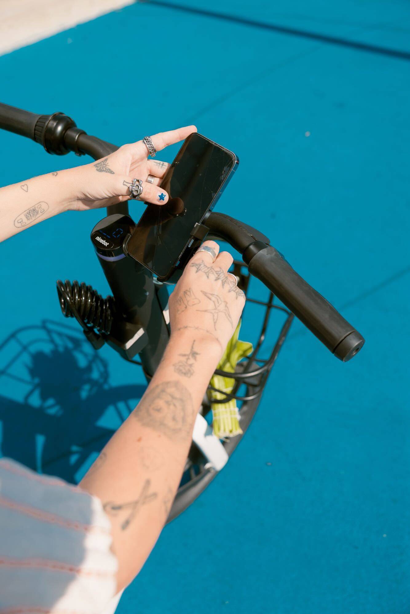 A rider using the Bird app on a phone mounted to an e-bike's handlebars